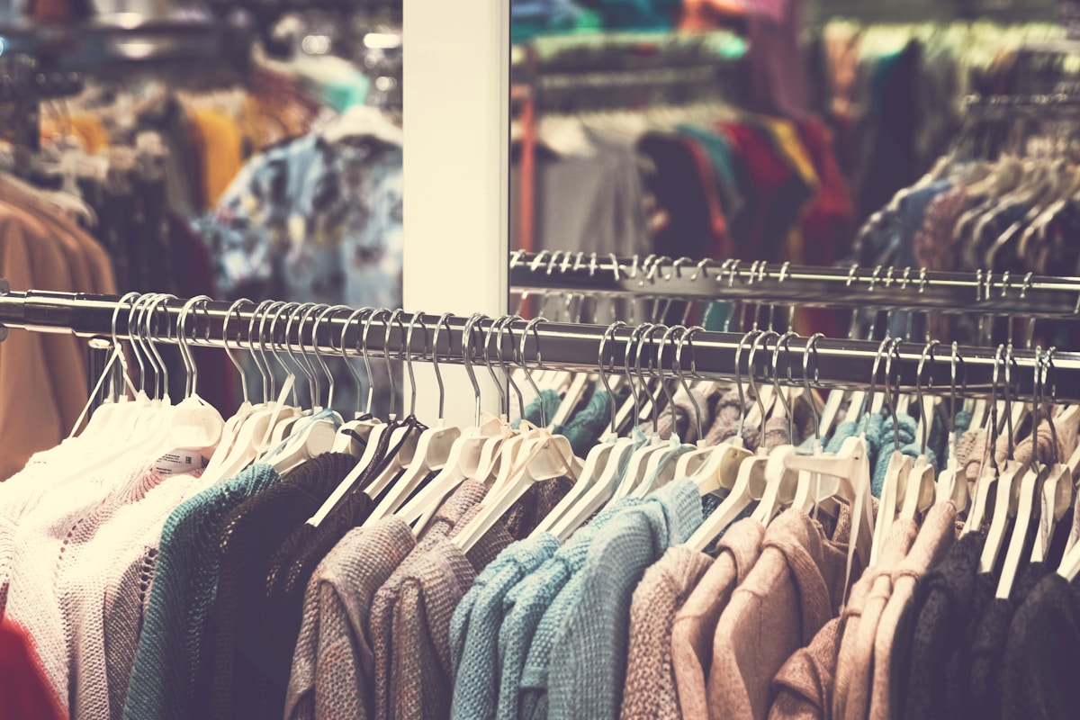Knit and sweater garments on a sourcing rack